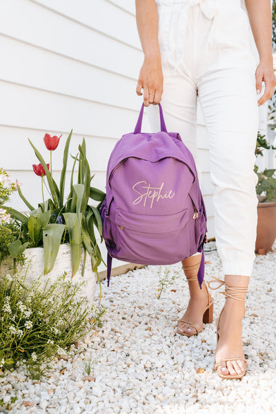 Personalised Gifts from The Label House COllection - Purple backpack with Stephie embroidered in rose gold. Red tulips in the garden